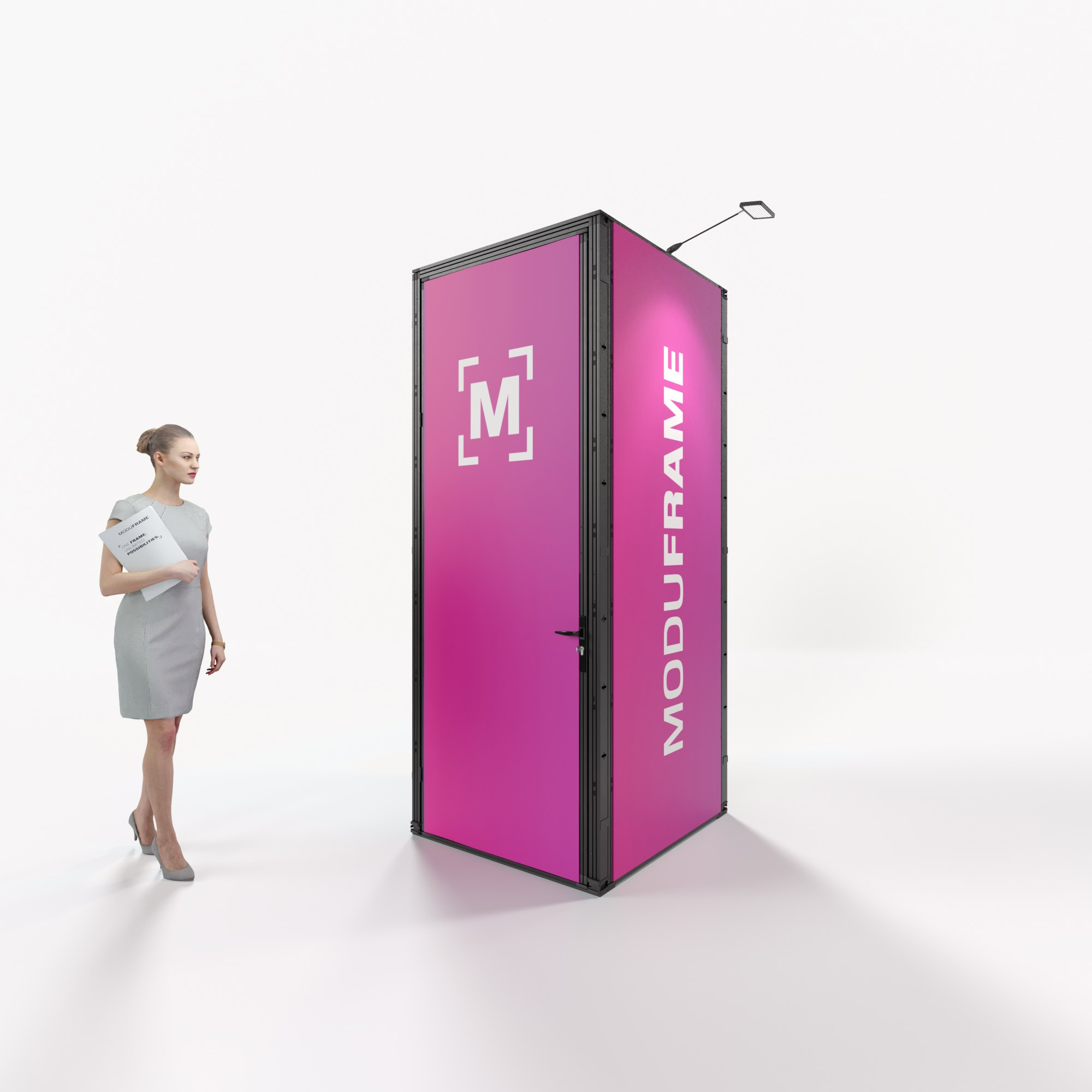 Eine Frau in einem grauen Kleid steht in einem modernen, geräumigen Büro und blickt auf eine große schwarze rechteckige Struktur mit der Aufschrift MODUFRAME und geometrischen Mustern darauf.