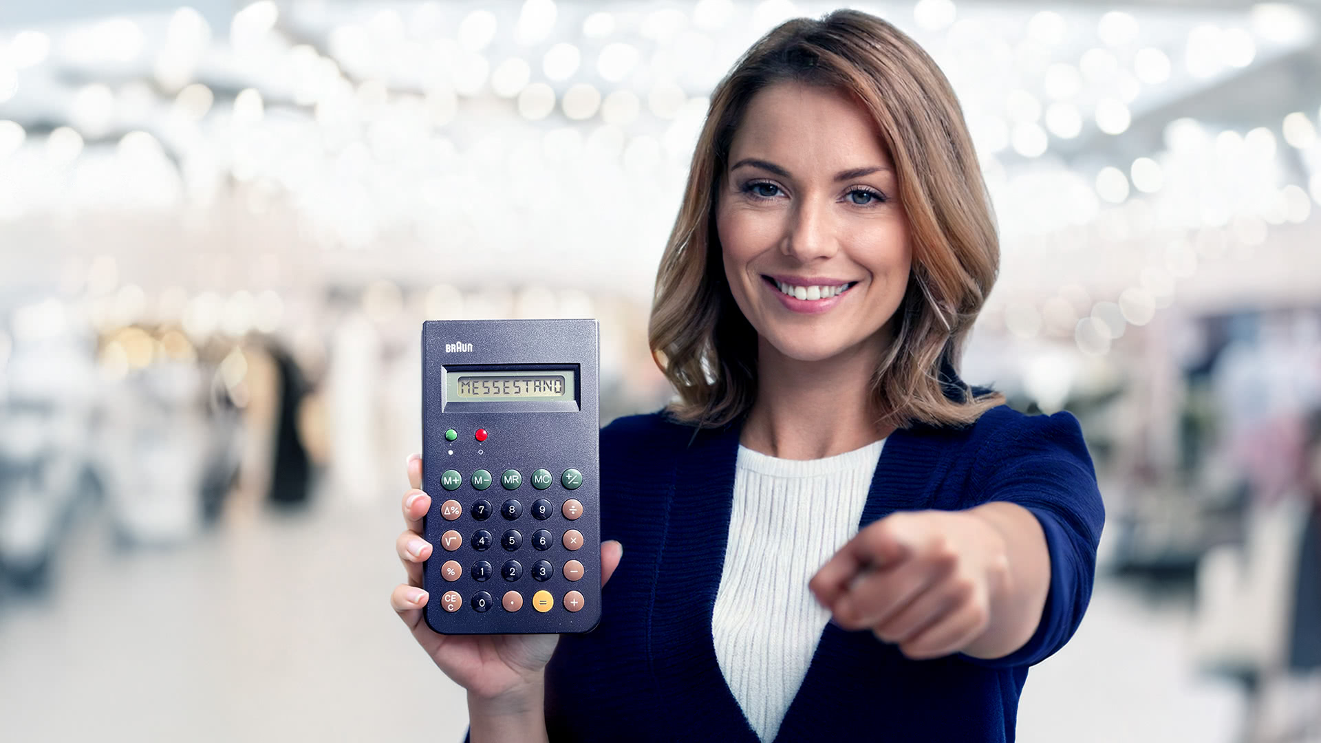 Frau hält einen Taschenrechner auf dem das Wort Messestand steht