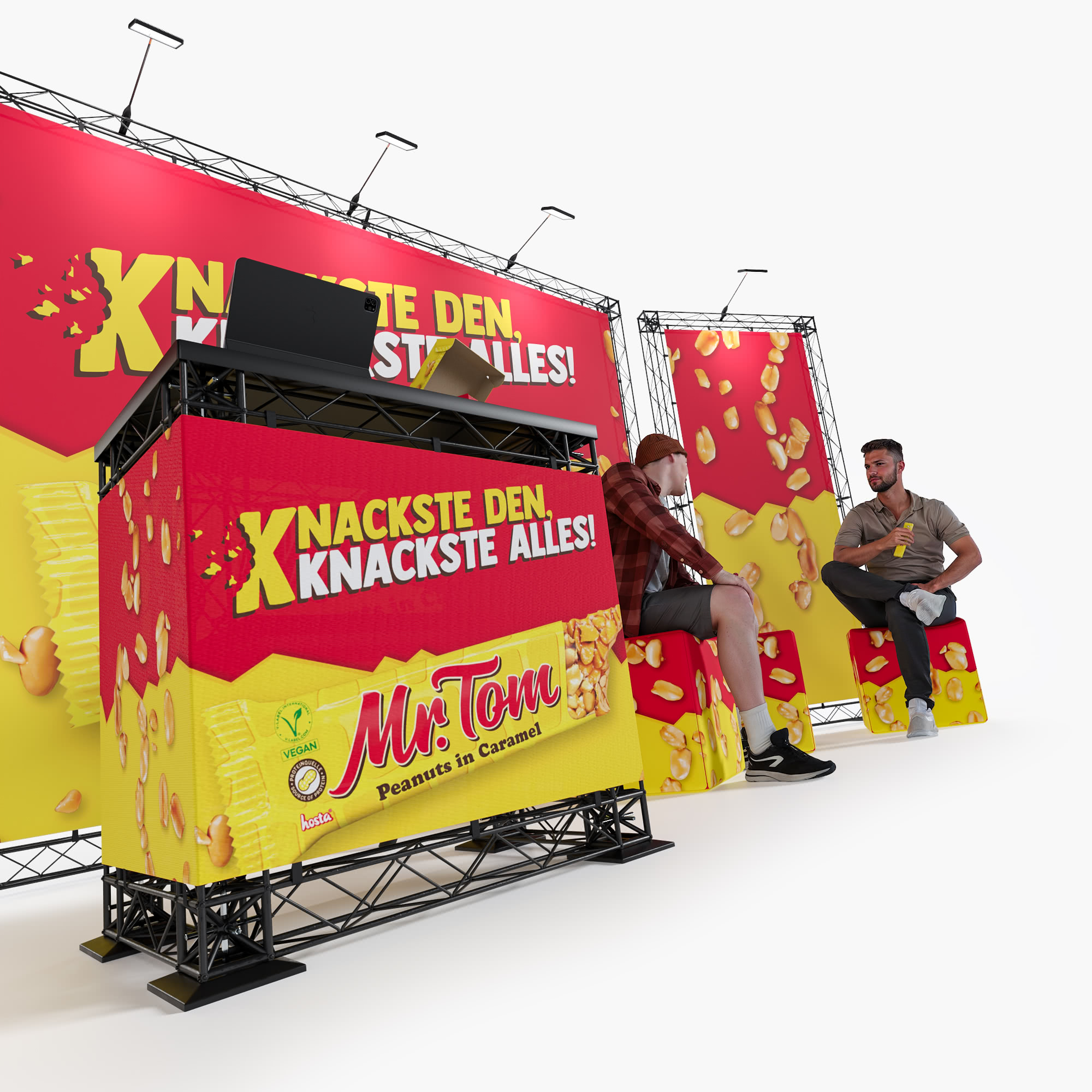 Ein Messestand zeigt leuchtende Banner und Theken für Mr. Tom Peanuts in Caramel. Zwei Personen sitzen und unterhalten sich in der Nähe des Standes, der mit Erdnuss- und Karamellgrafiken dekoriert ist.