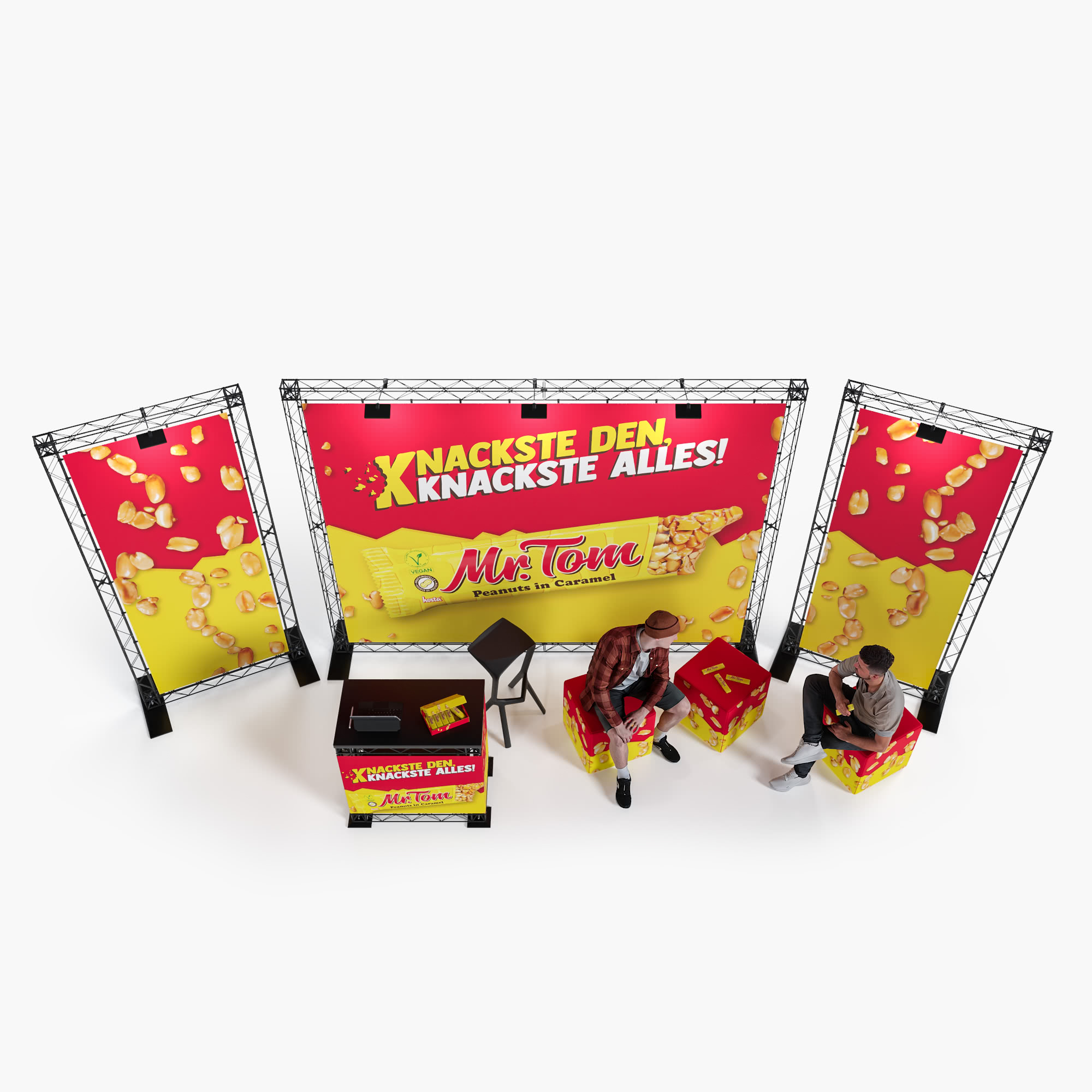 Zwei Personen sitzen an einem Werbestand für Mr. Tom, umgeben von leuchtend roten und gelben Bannern mit Erdnüssen und dem Slogan Knackste den, knackste alles! Der Stand besteht aus Aufstellern, einem Tisch und Stühlen mit Markenlogo.